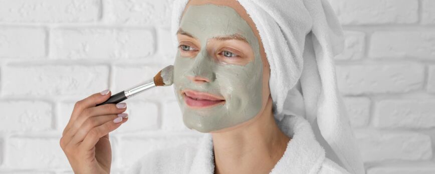 Mulher aplicando remédio facial em plano médio