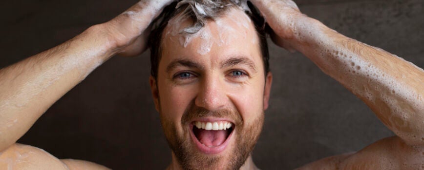 Vista frontal de homem lavando o cabelo