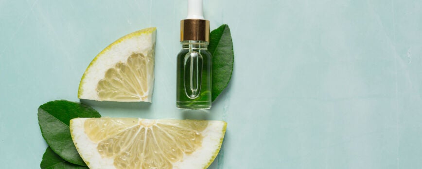 Frasco de soro de óleo de grapefruit colocado sobre um fundo de luz verde