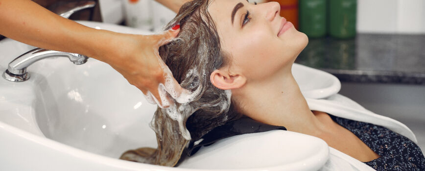 Homem lavando o cabelo de um cliente