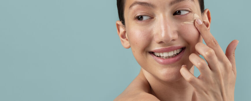Vista lateral mulher aplicando creme facial