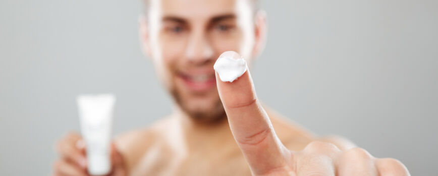 Idosa sorridente com algodão para desmaquilhar