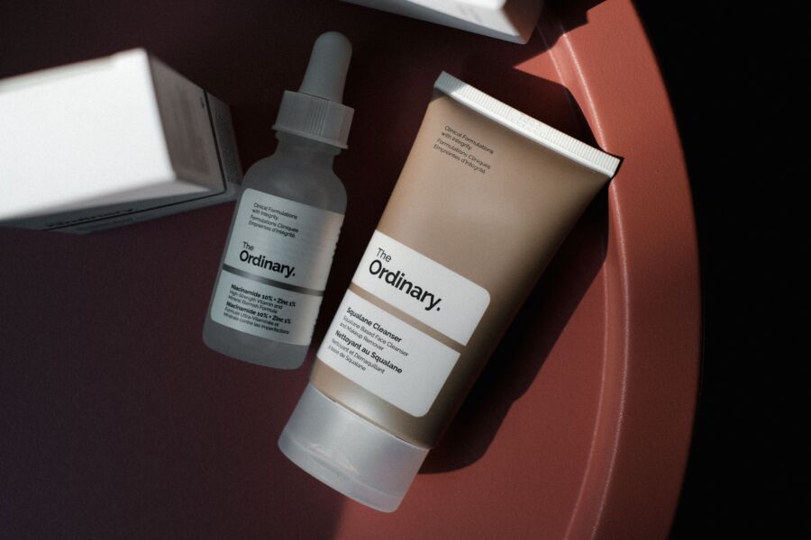 Foto minimalista chique de produtos de cuidados com a pele The Ordinary sobre um fundo cor de rosa.